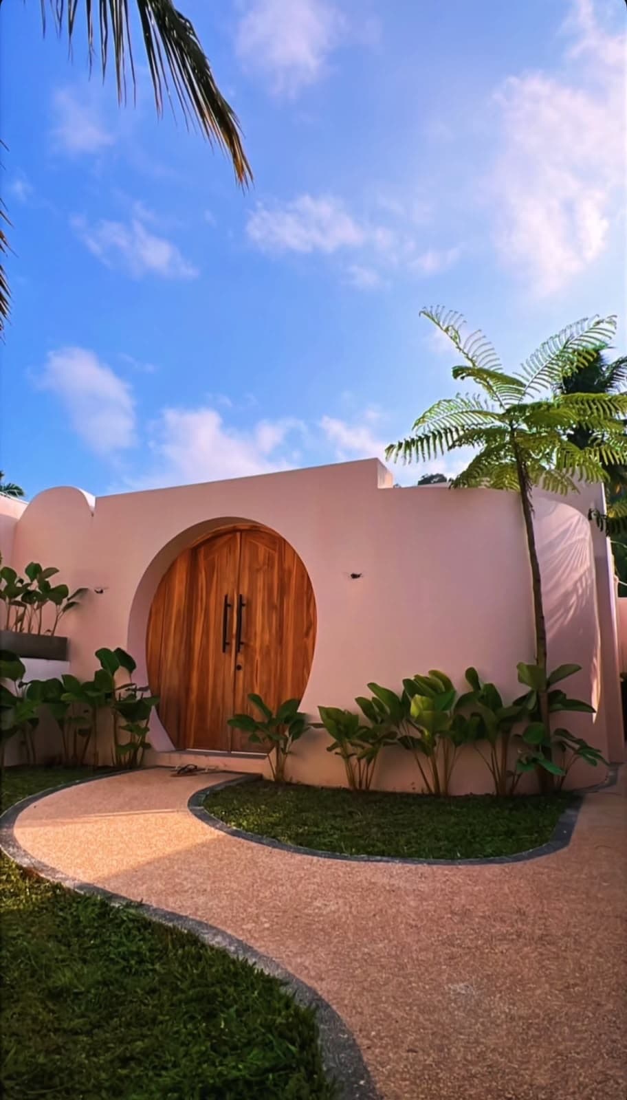 Entrada de la villa NALMA en Kuta, con portón circular de madera