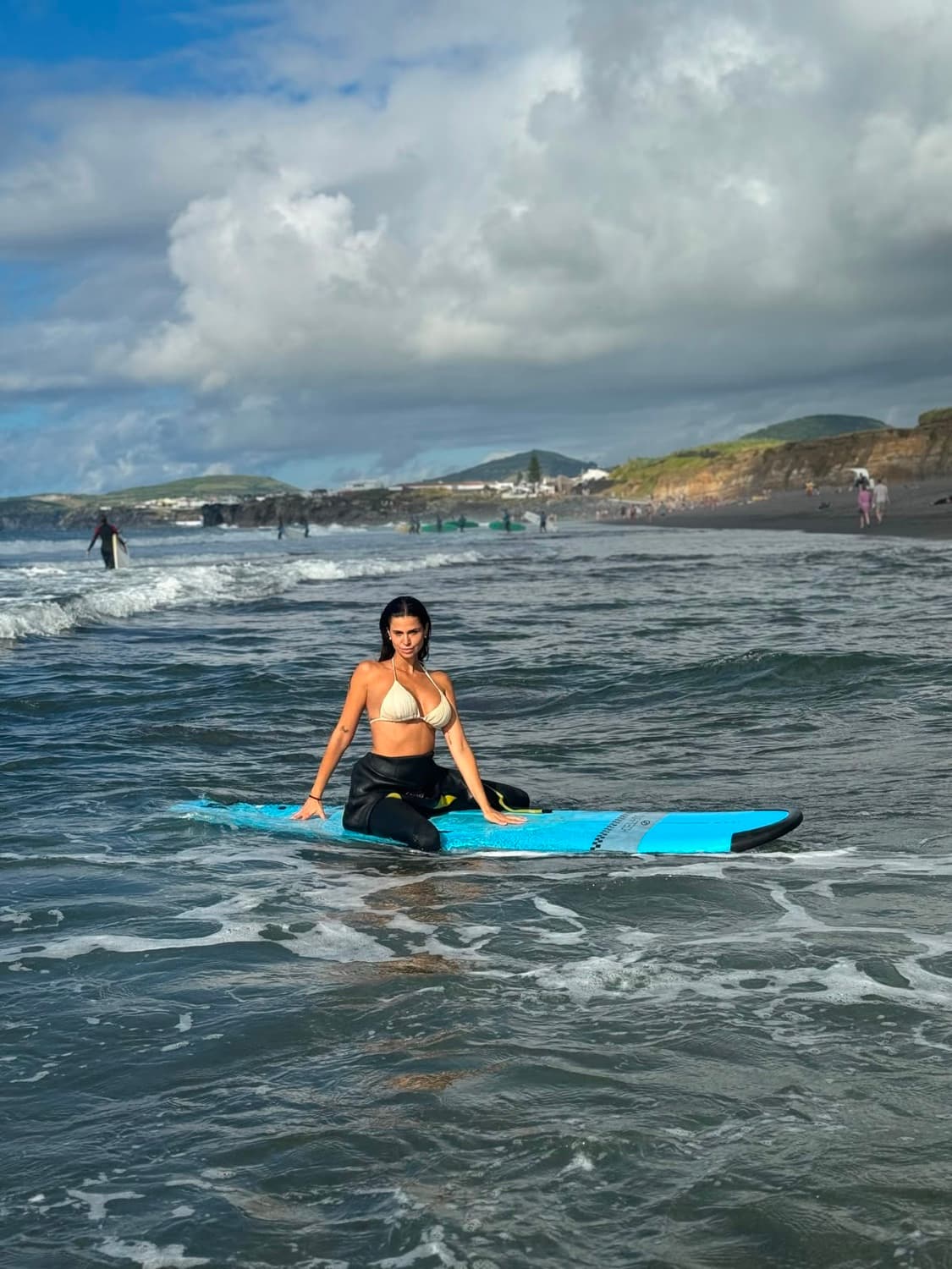 Marina Ruiz sobre una tabla de surf en el mar